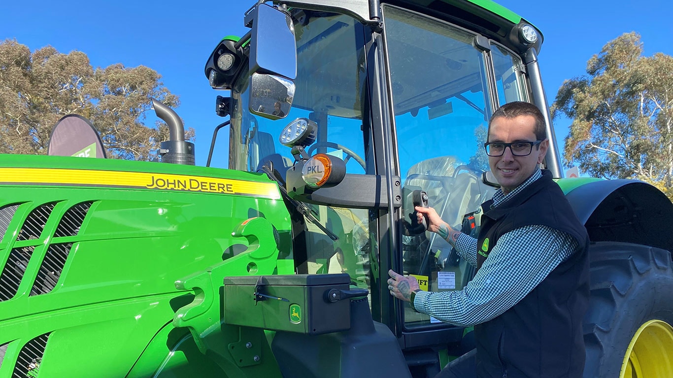 Jarred Bourke in front of John Deere equipment