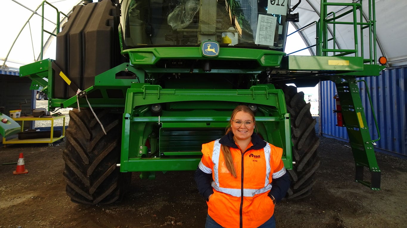 Kym Thorne in front of John Deere equipment