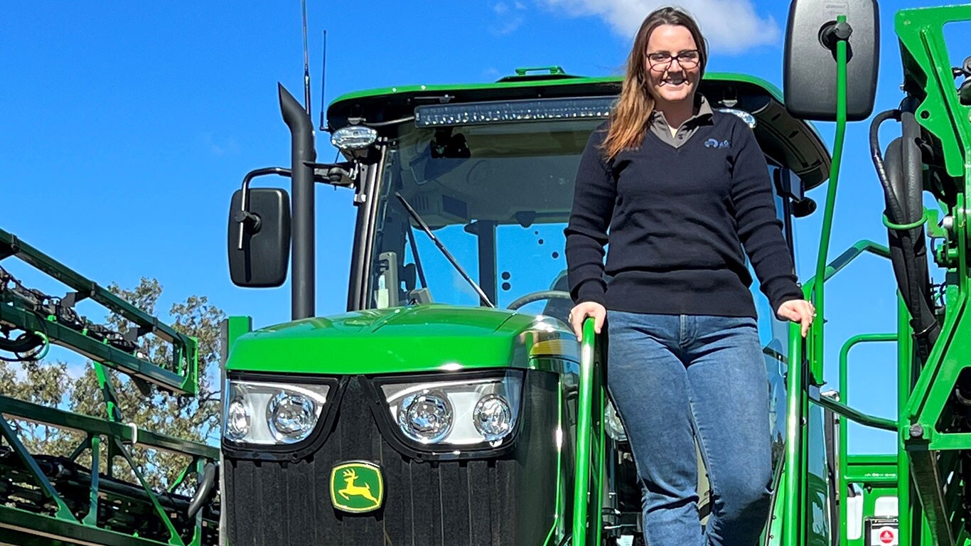Lauren Cortes in front of John Deere equipment