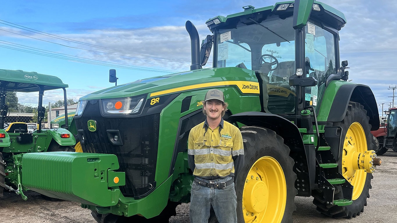 Darcy Miller in front of John Deere equipment