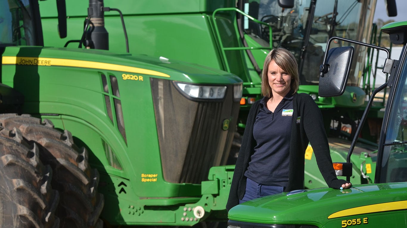 Belinda Gade in front of John Deere equipment