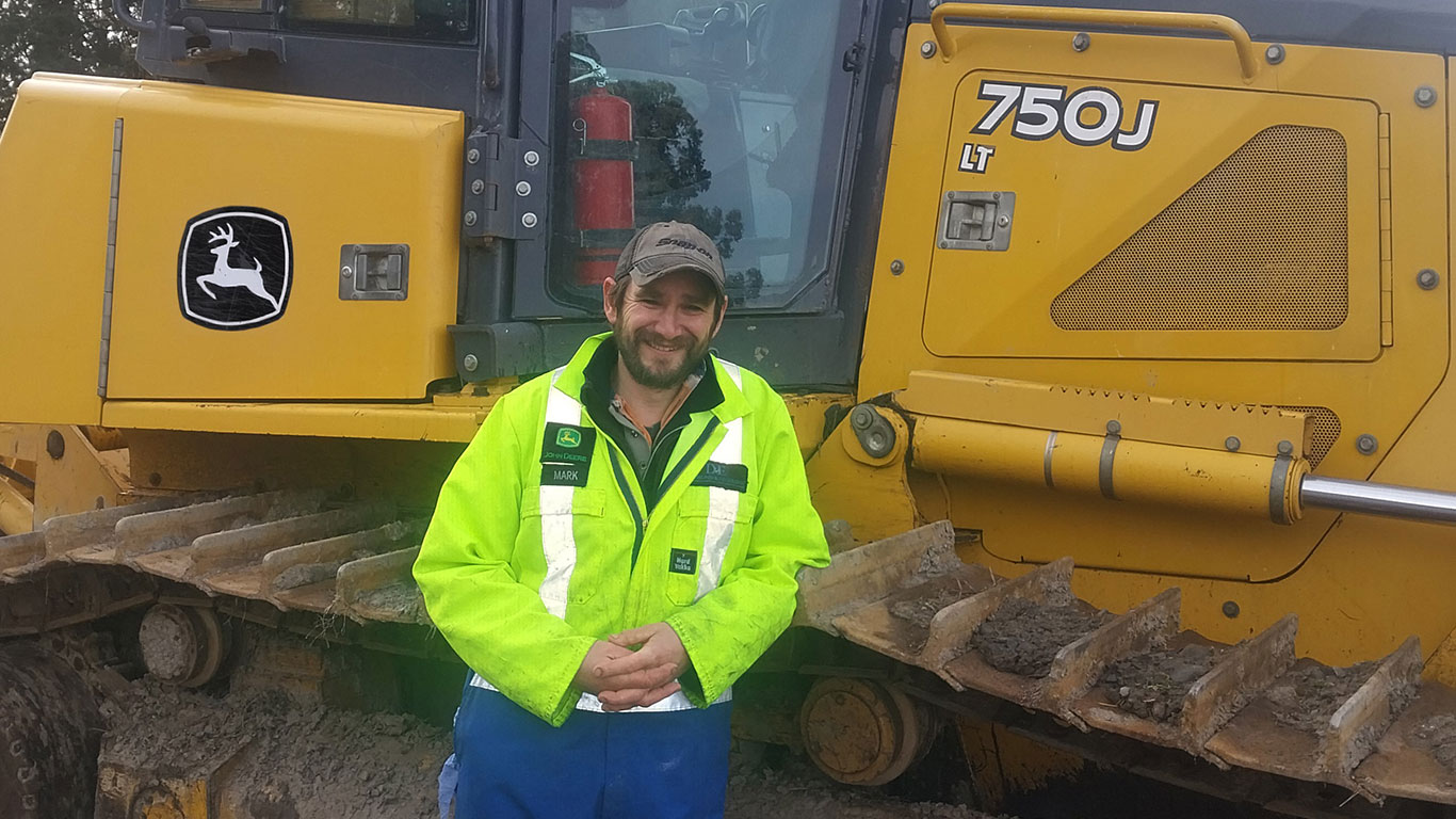 Mark Haughton in front of John Deere equipment