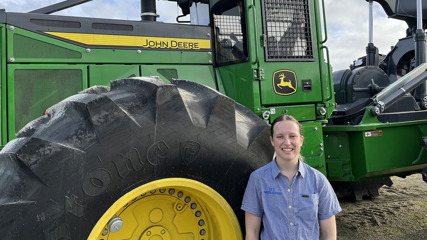 Paige Hunter in front of John Deere equipment