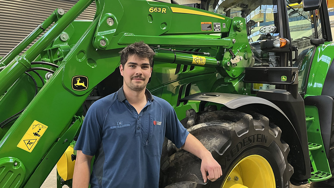 Dylan Bruce in front of John Deere equipment