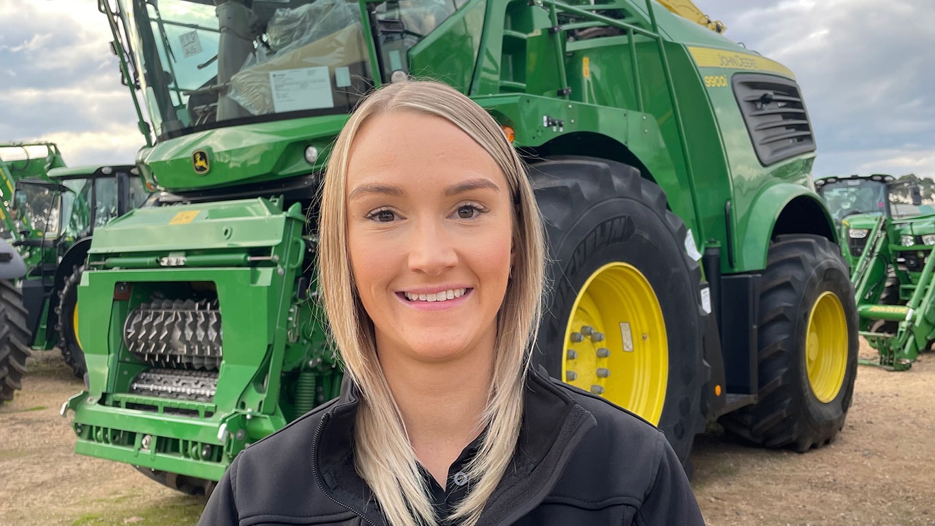 Sarah Lewis in front of John Deere equipment