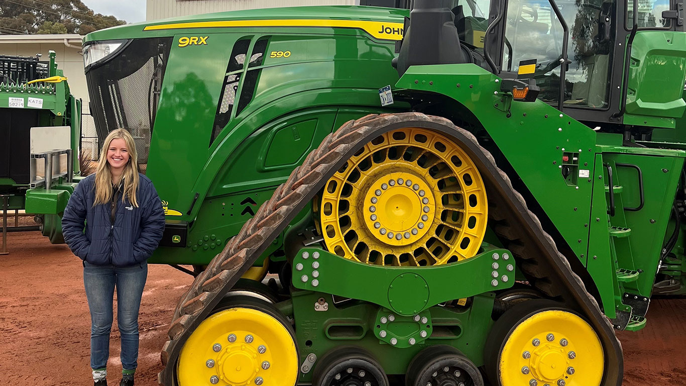 Poppy Blohm in front of John Deere equipment