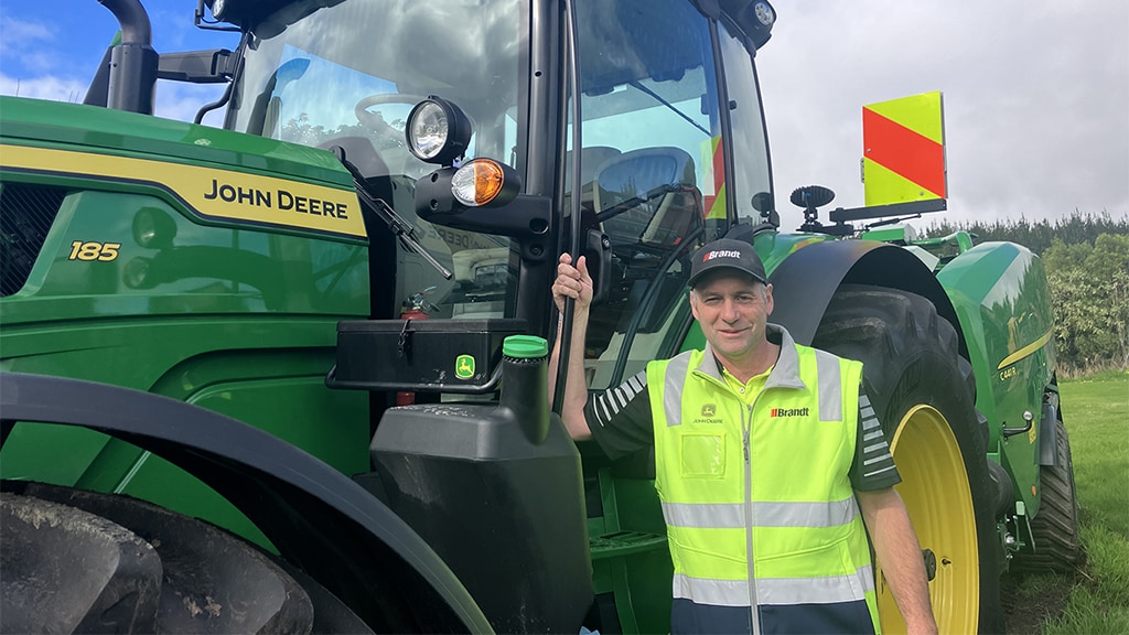 Bryce Dickson posing in front of John&nbsp;Deere equipment