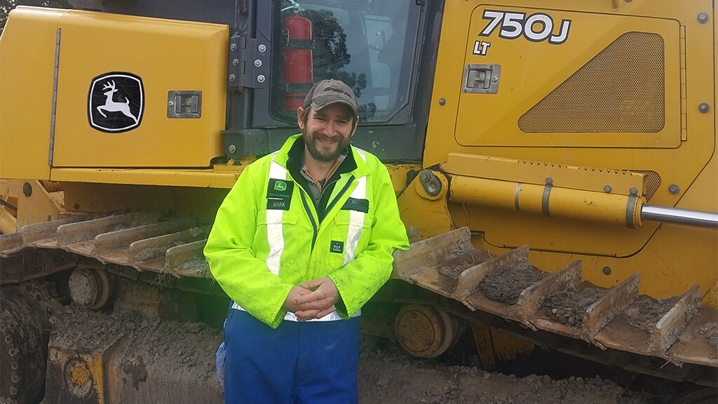 Mark Haughton posing in front of John&nbsp;Deere equipment