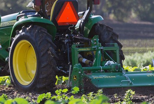 John Deere utility tractor with attachment.