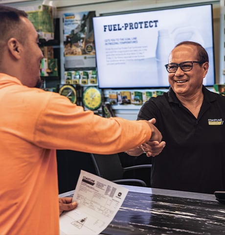 A John Deere dealer shaking hands with a customer
