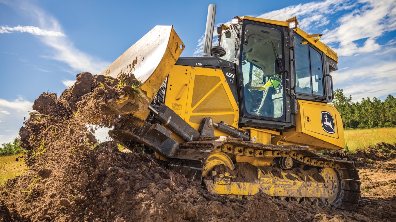 Side view of a 450P Dozer moving dirt.
