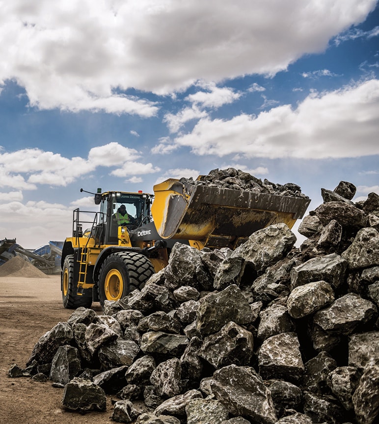 Deere construction equipment piling up rocks