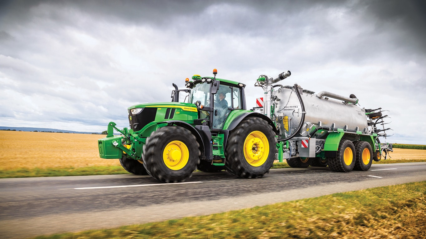 6M220 tractor with sprayer attached on a road