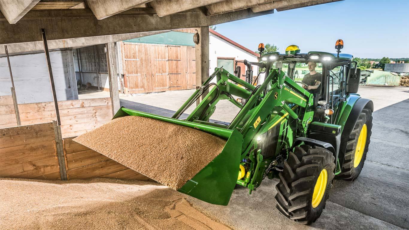 A 603M Loader moving a bucket of dirt on a job site