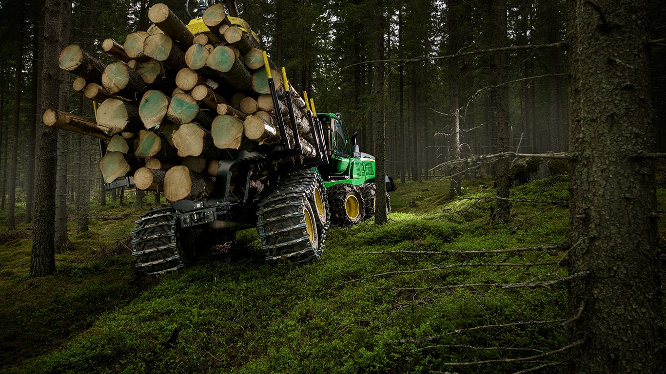John Deere 1510G forwarder is carrying logs in the forest