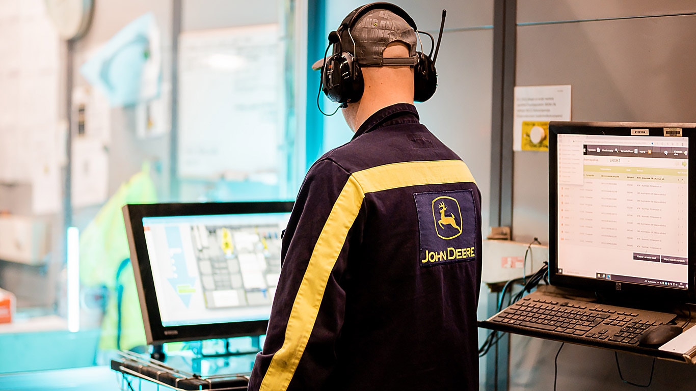 A man with headphones in front of a screen