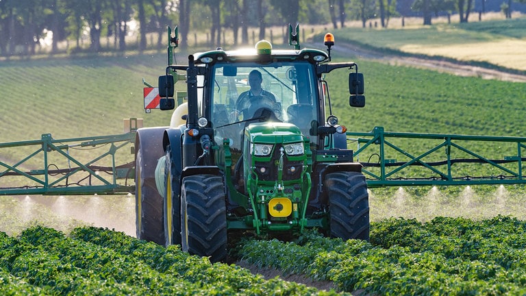 Person driving a tractor in a field