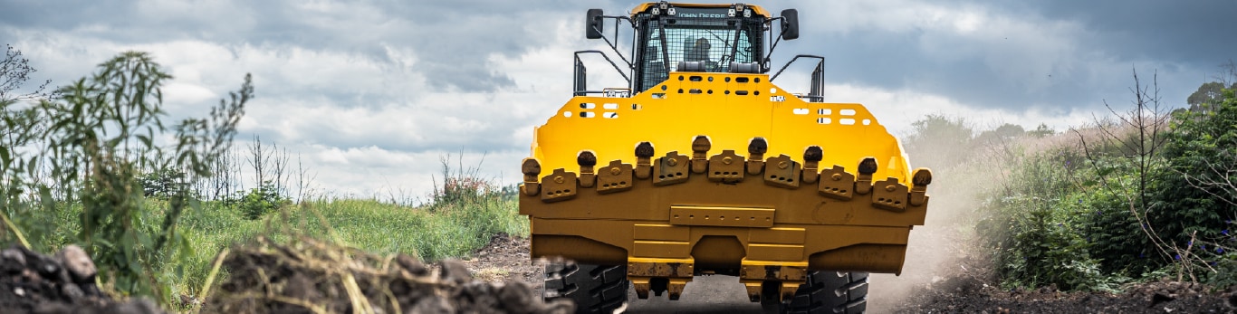 944X Tier Hybrid Wheel Loader driving down dirt road