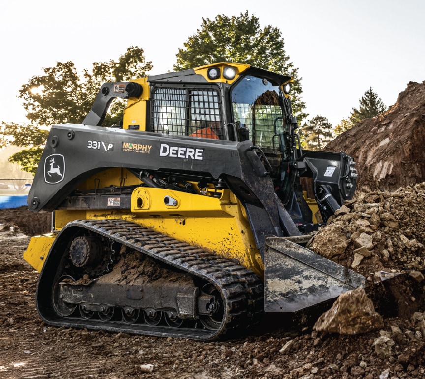 compact track loader digging up soil