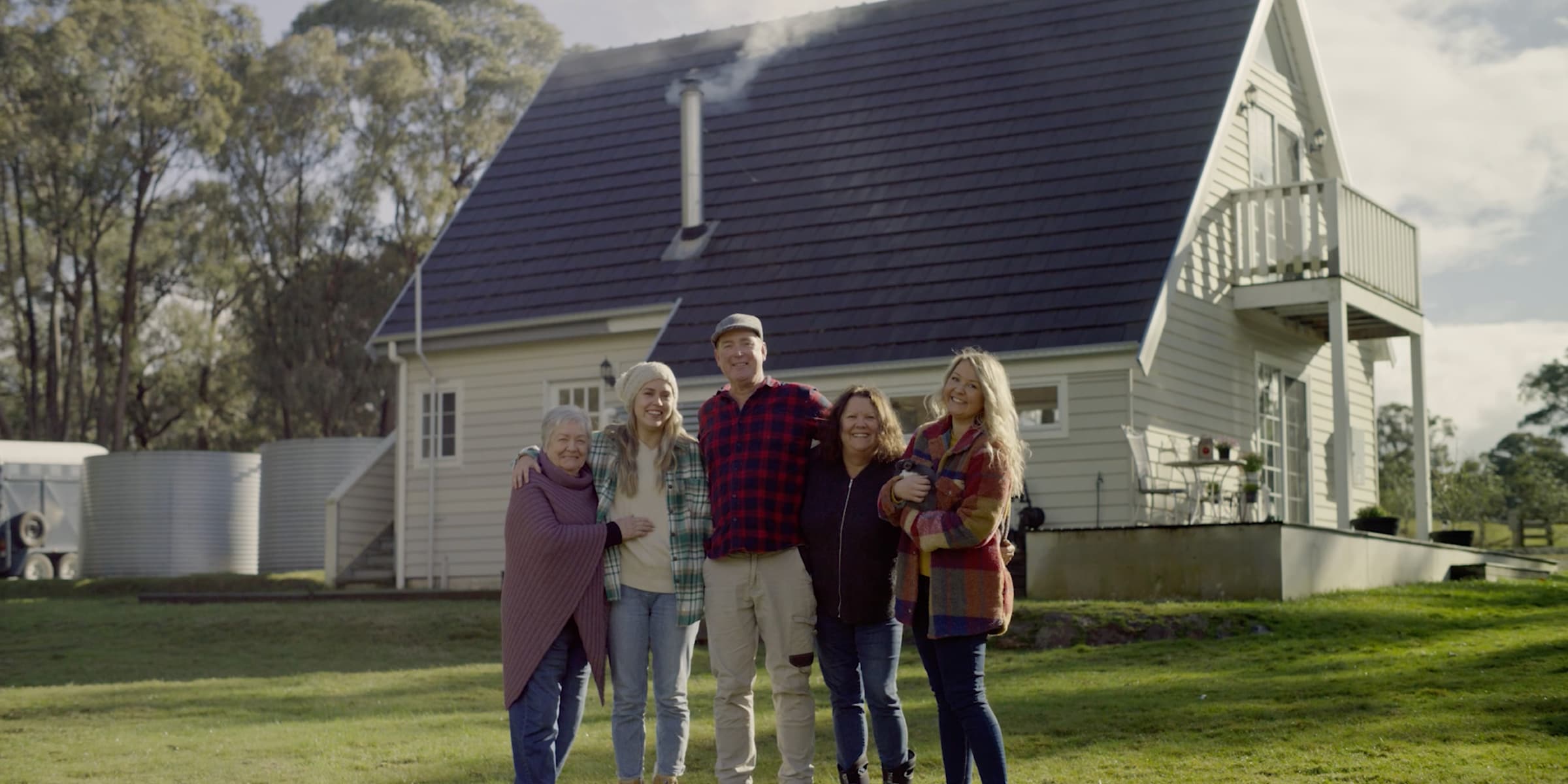 A portrait of the Brooks family, one man & four women, in front of their home