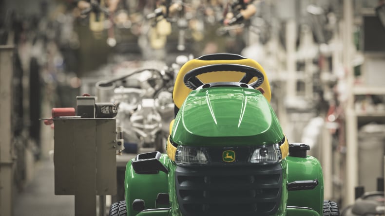 A John Deere 100 series ride on lawn mower on a factory production line.