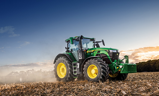 6R tractor tilling a field with dust surrounding it.