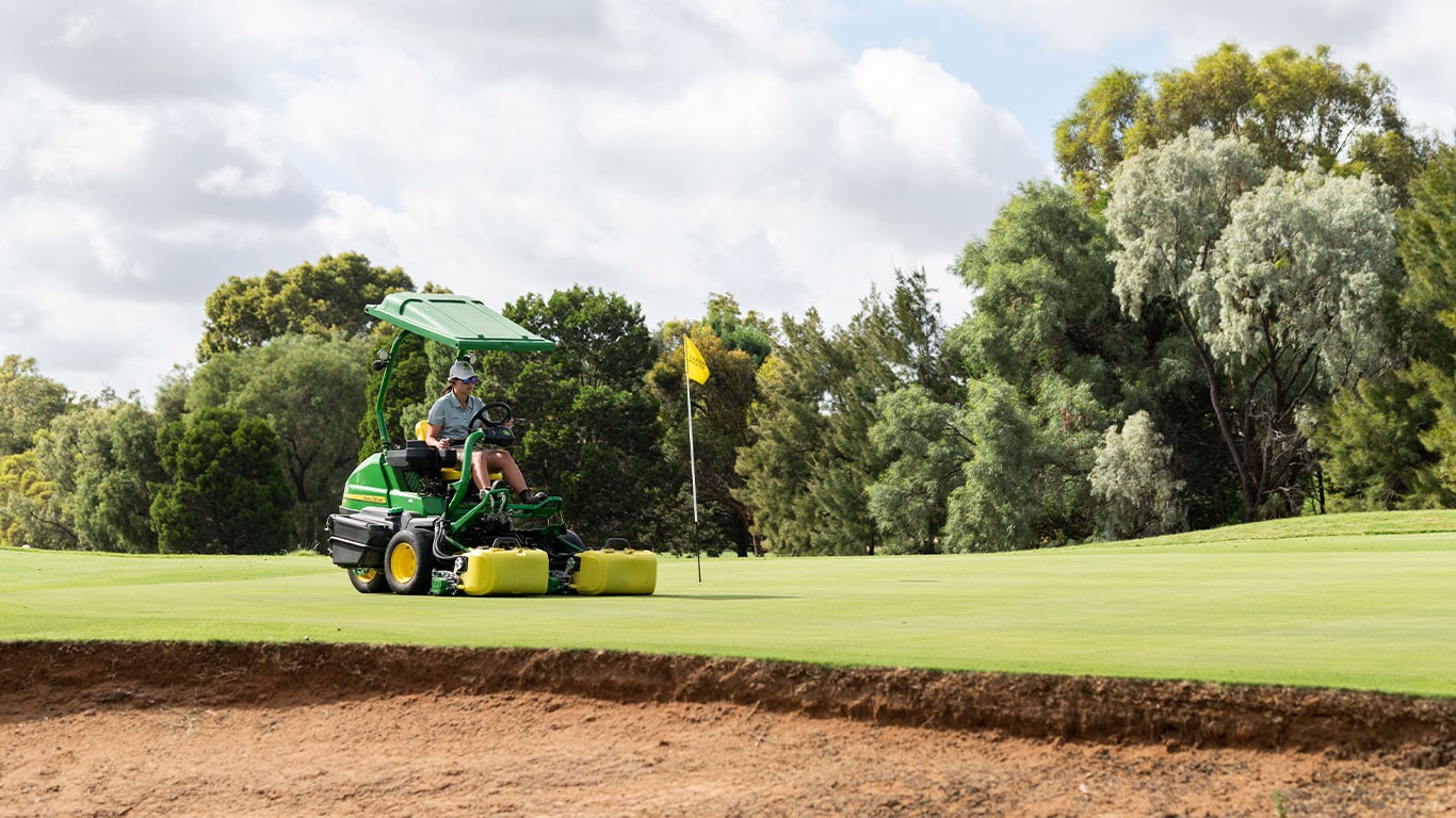 Annabelle Southall preparing a green on a John Deere Greens Mower for the TPS Murray River tournament.