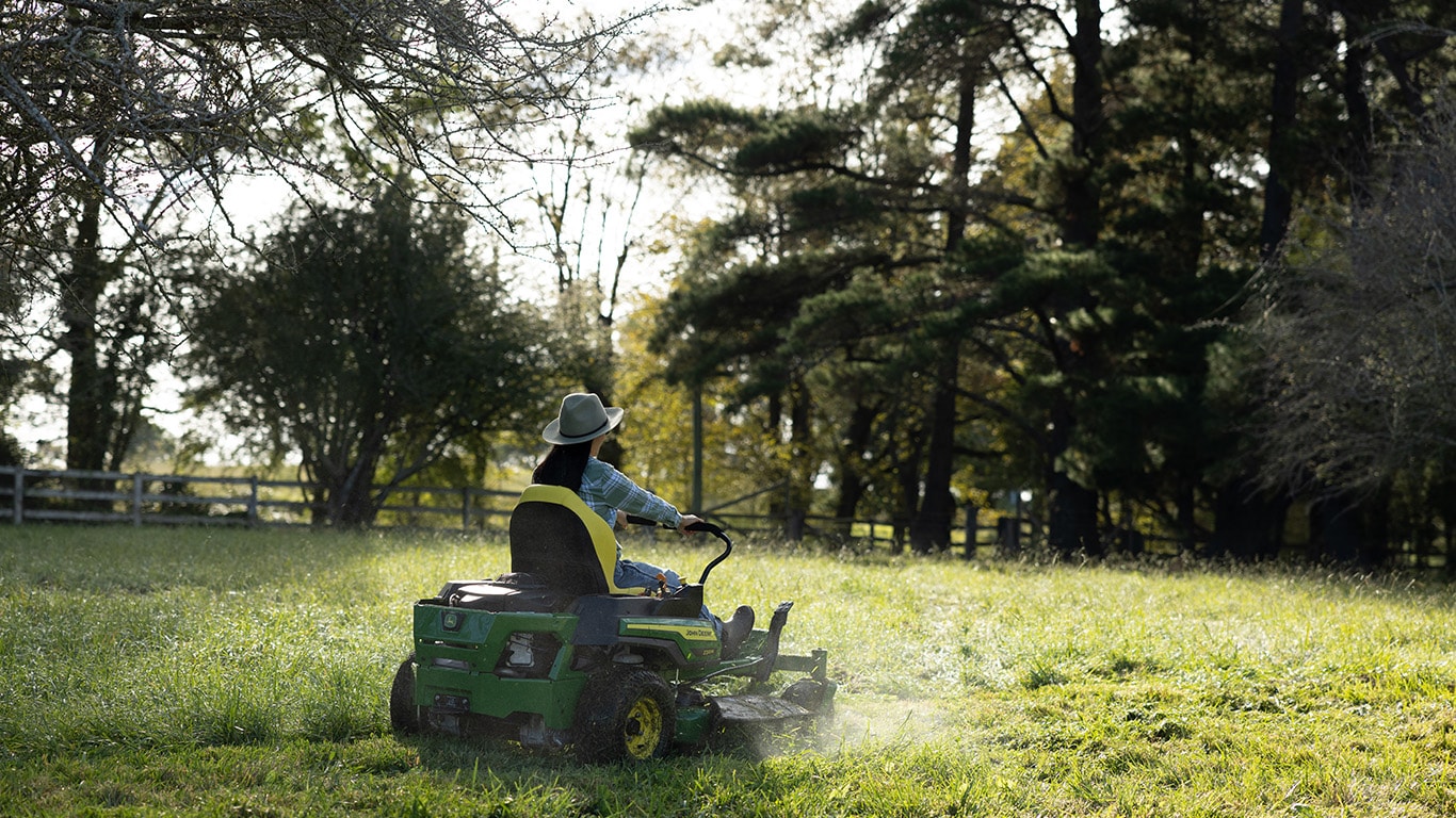 woman on a John Deere compact tractor