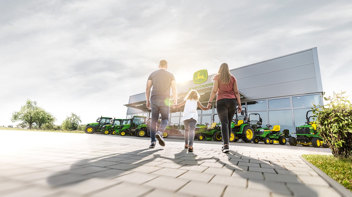 family walking into a John Deere rural lifestyle equipment dealer
