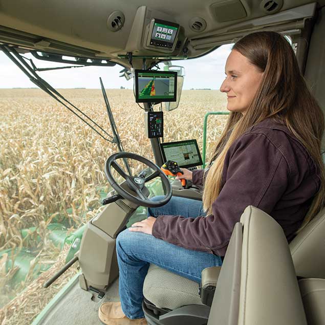 Field image of women inside the John Deere agriculture equipment cabin