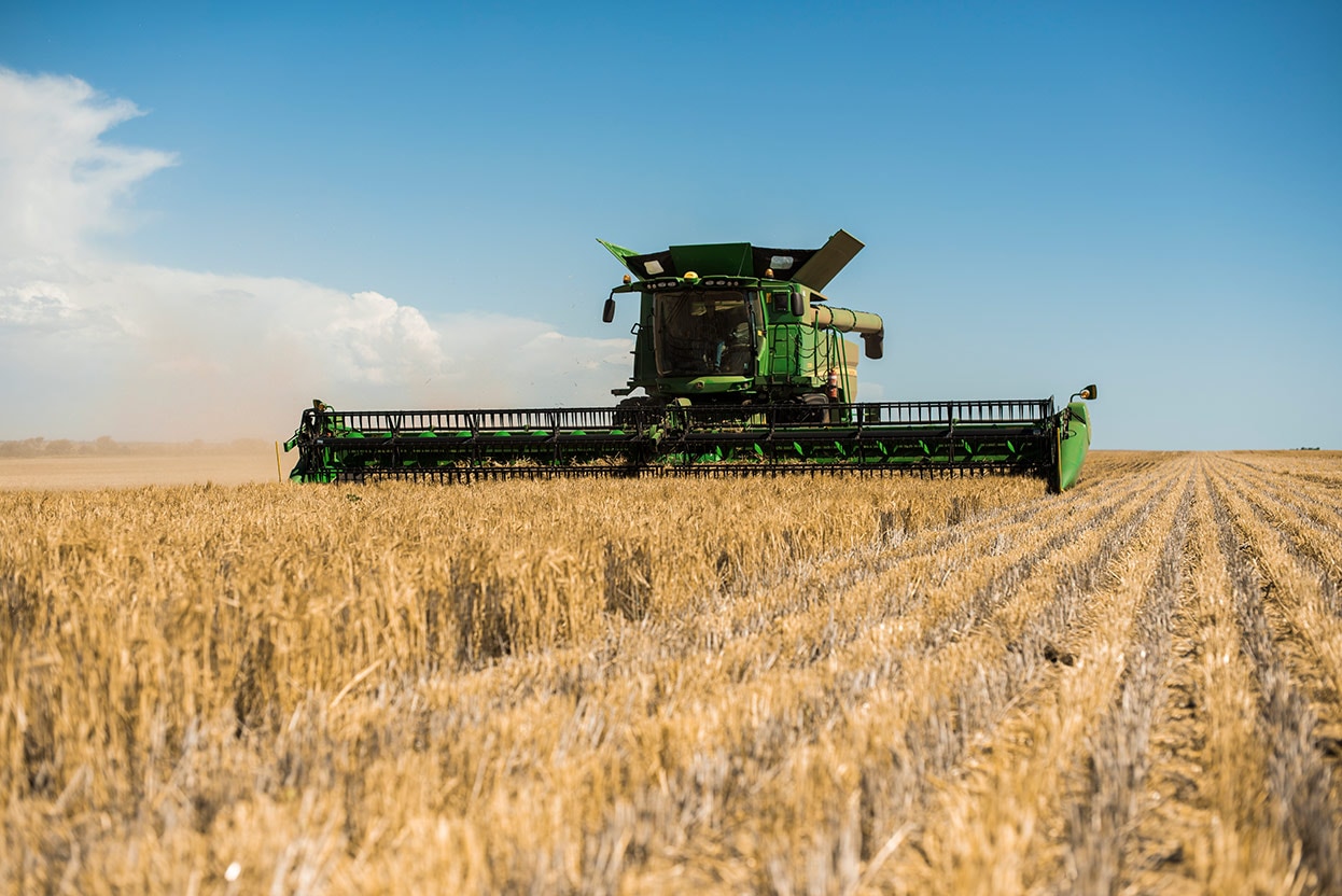John Deere S780 Combine harvesting wheat in a field