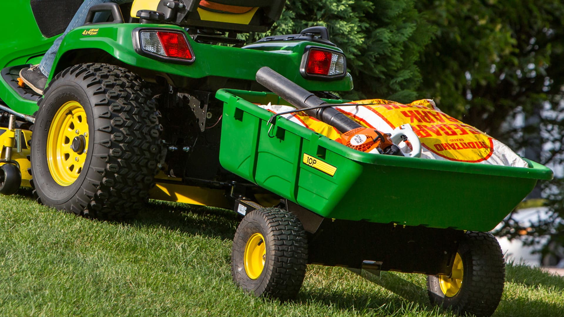 Closeup shot of ride-on mower pulling a cart