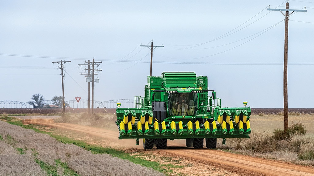 Image of a cotton harvester driving down a country road