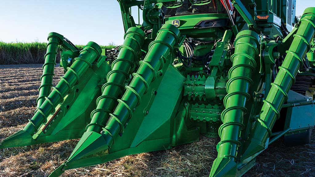 Photo showing the heavy-feeding front end of a CH Series Sugar Harvester in a field.