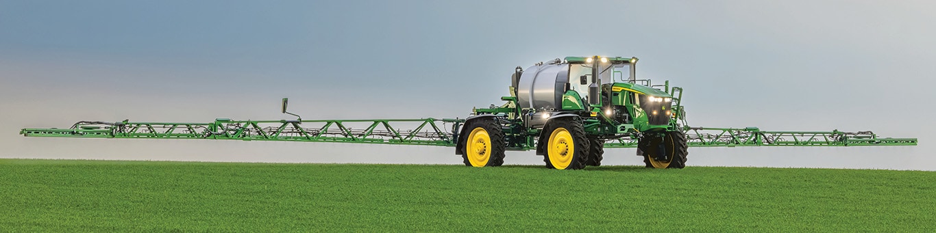 John Deere Self-Propelled Sprayer &ndash; with booms fully extended &ndash; spraying in a field.