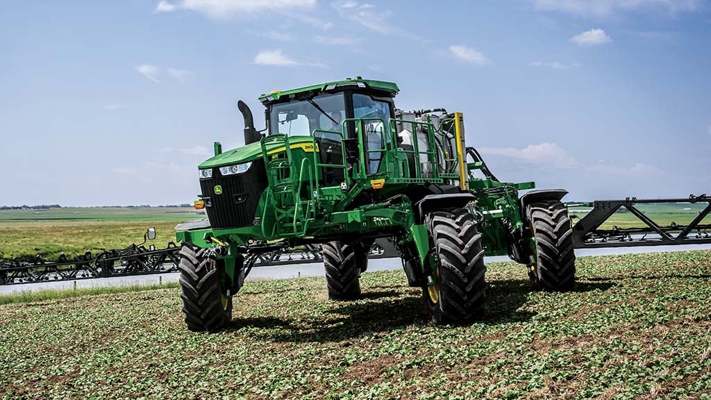 John Deere self-propelled sprayer with all wheels angled, showing four-wheel and crab steer.