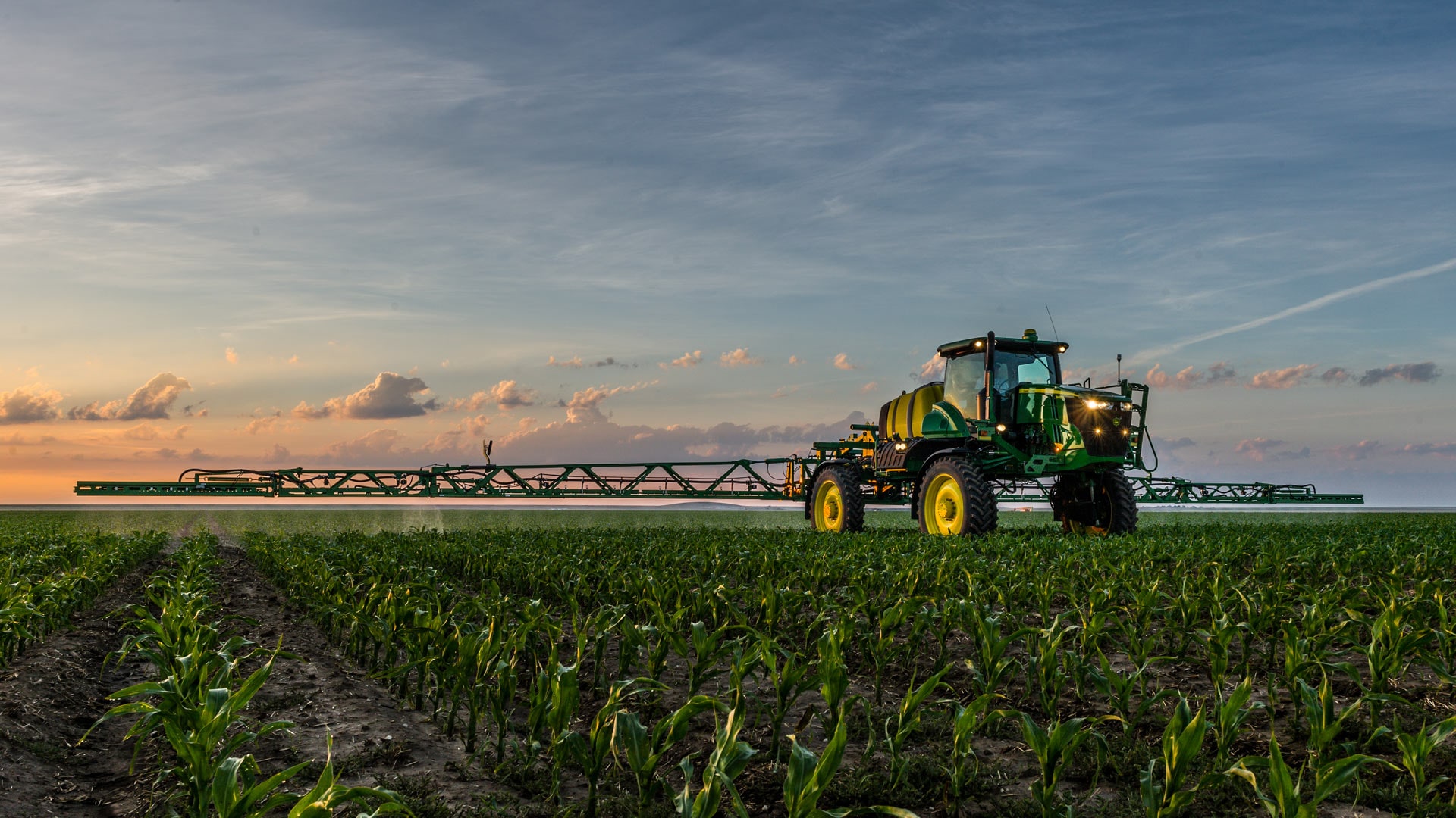 John Deere sprayer in field with boom extended