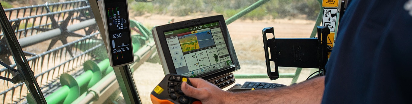 Farmer interacting with precision ag technology in tractor cab