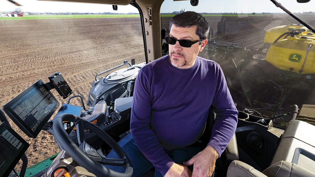 Close-up view of operator in the cab of a high-horsepower tractor.
