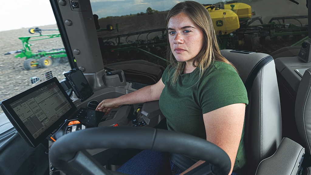 In-cab view of operator driving a high-horsepower tractor.