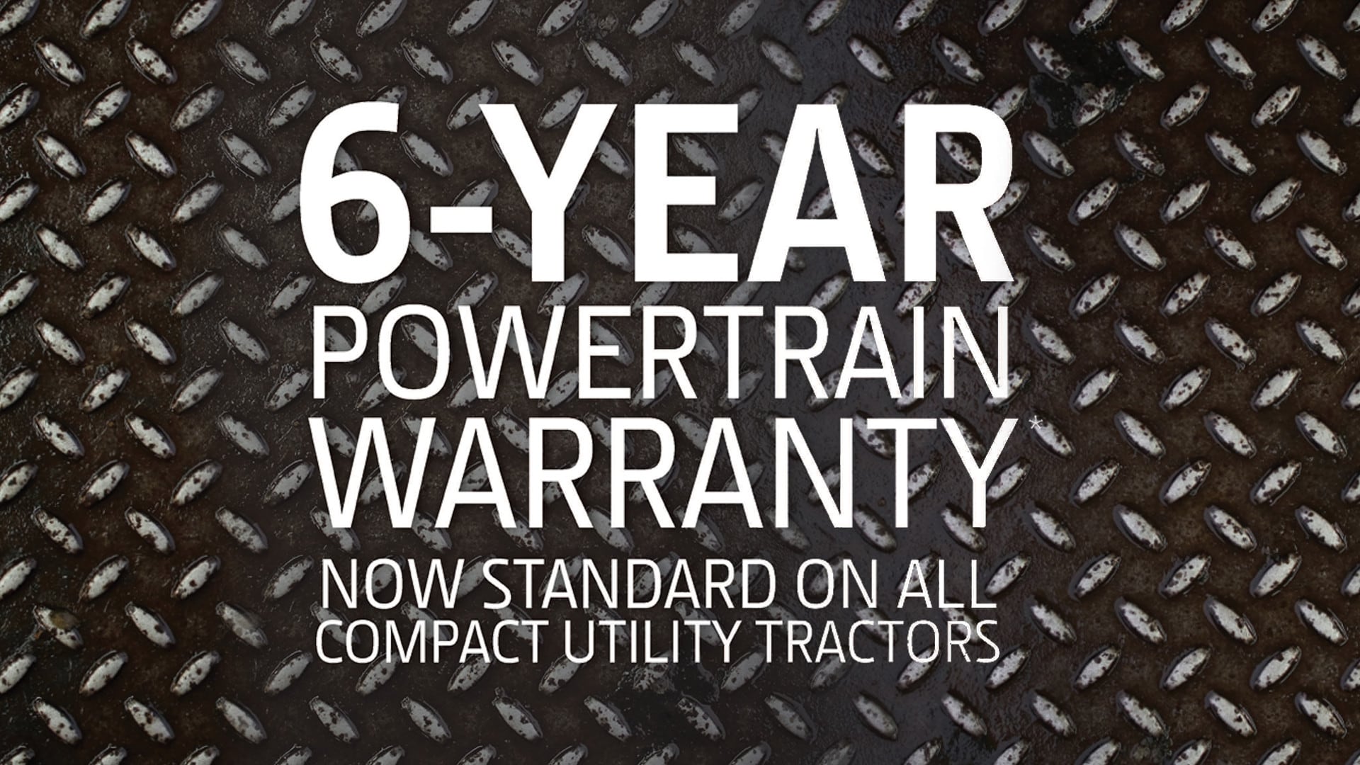 Text on a metal background that says "6-Year Powertrain Warranty Now standard on all compact utility tractors"